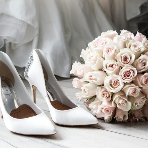 Elegant bridal shoes and bouquet of roses perfect for wedding inspirations.